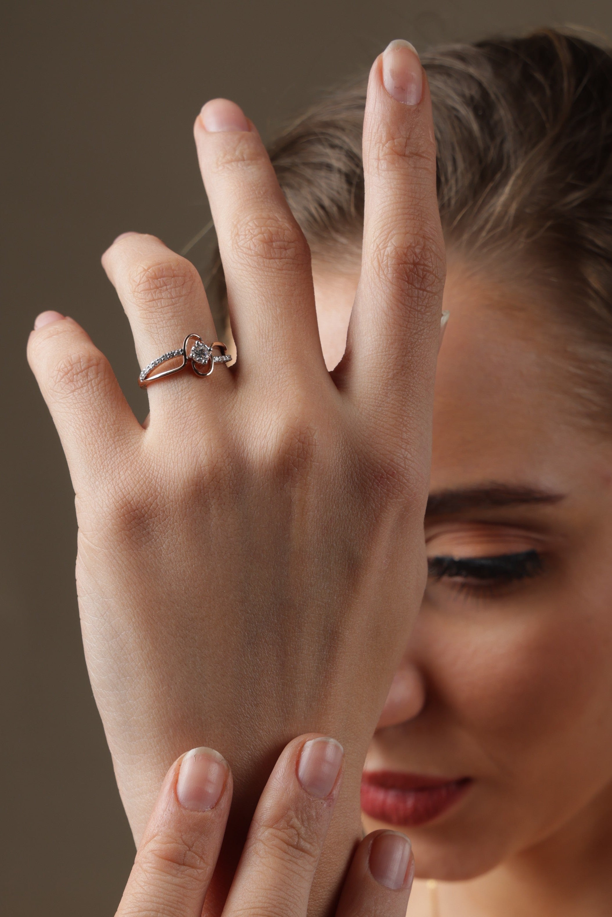 Woman wearing rings on her fingers with a neutral background