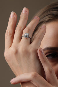 Woman wearing two rings on her fingers against a neutral background
