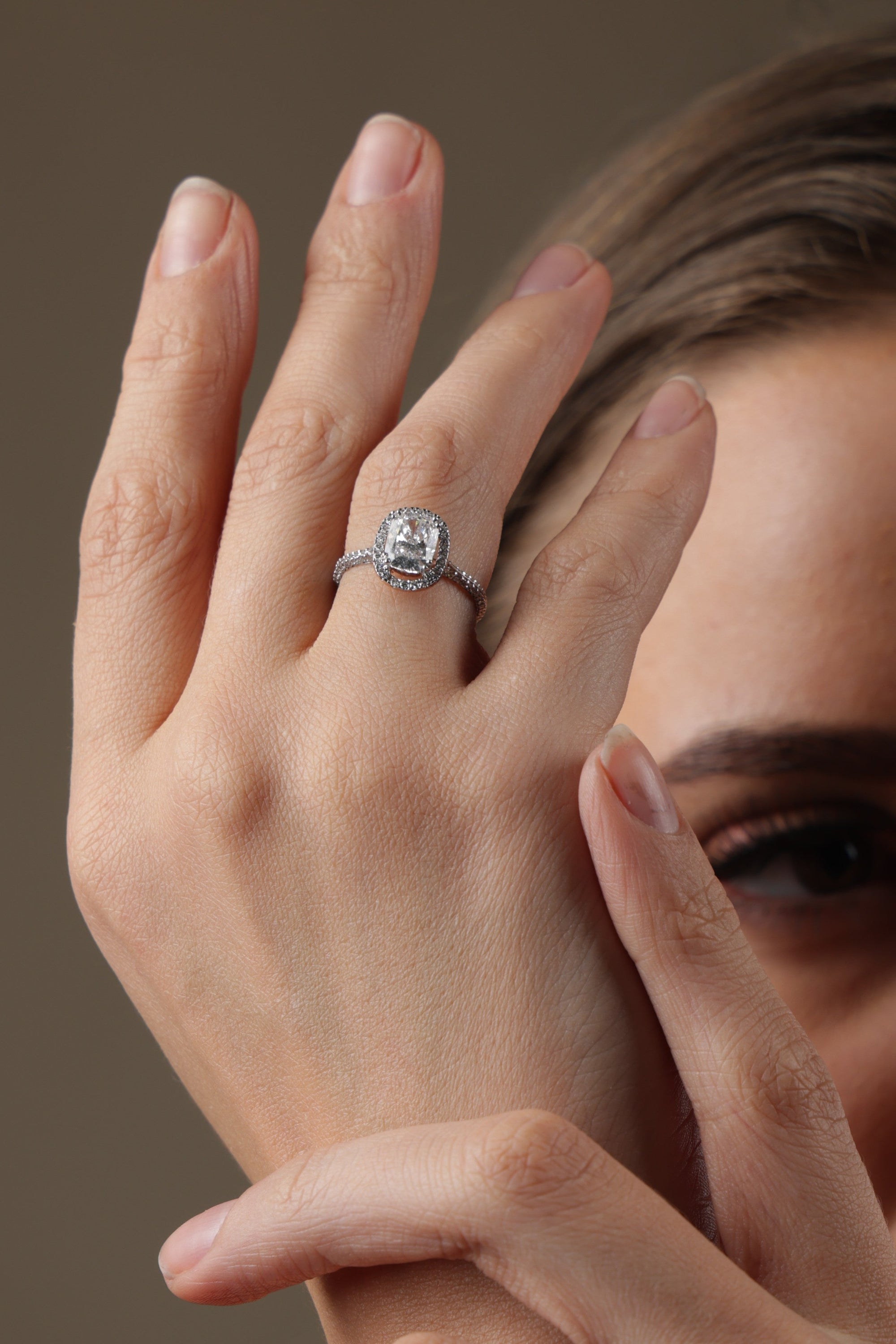 Woman wearing two rings on her fingers against a neutral background