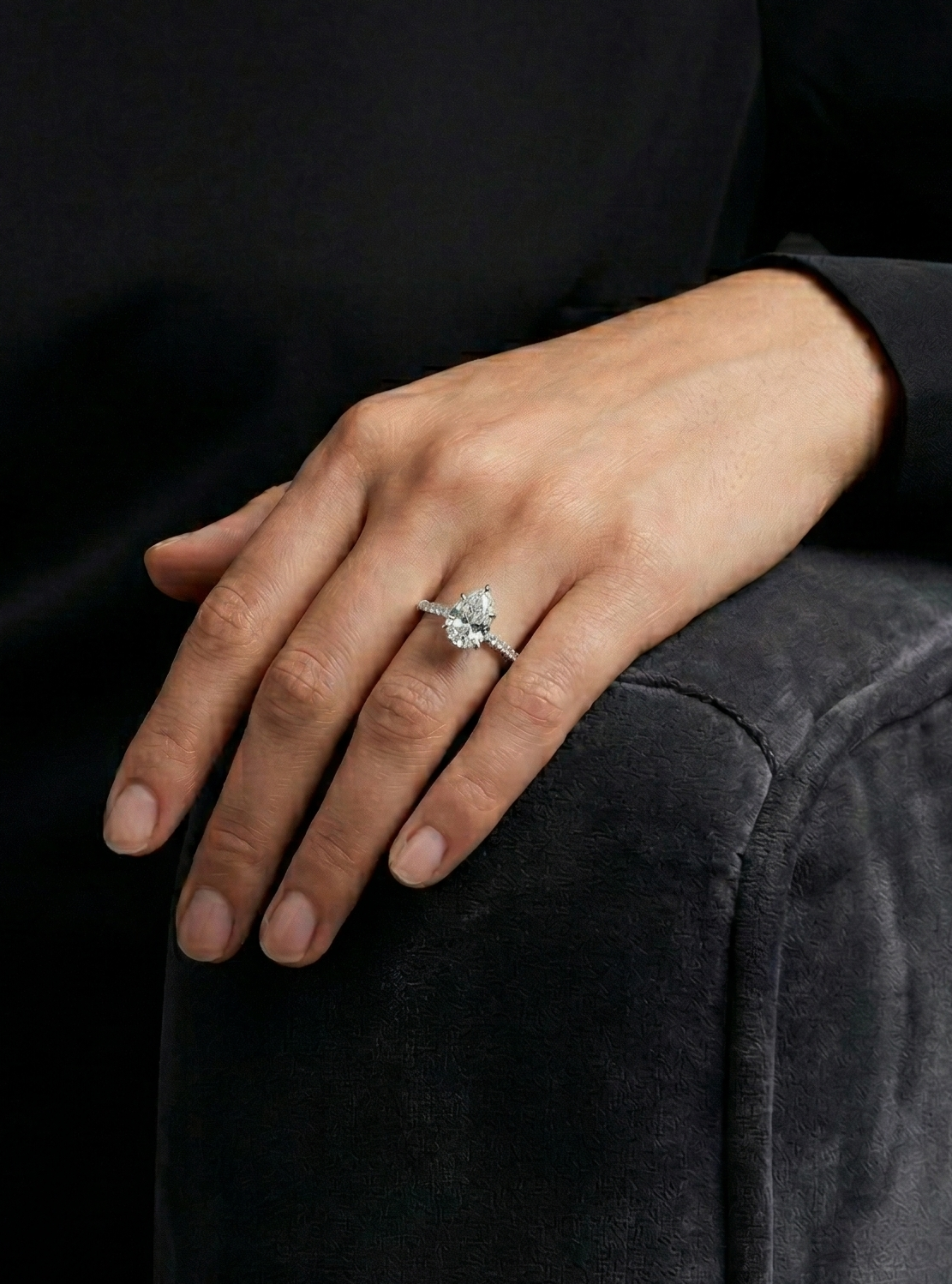 Person wearing a ring on a dark background